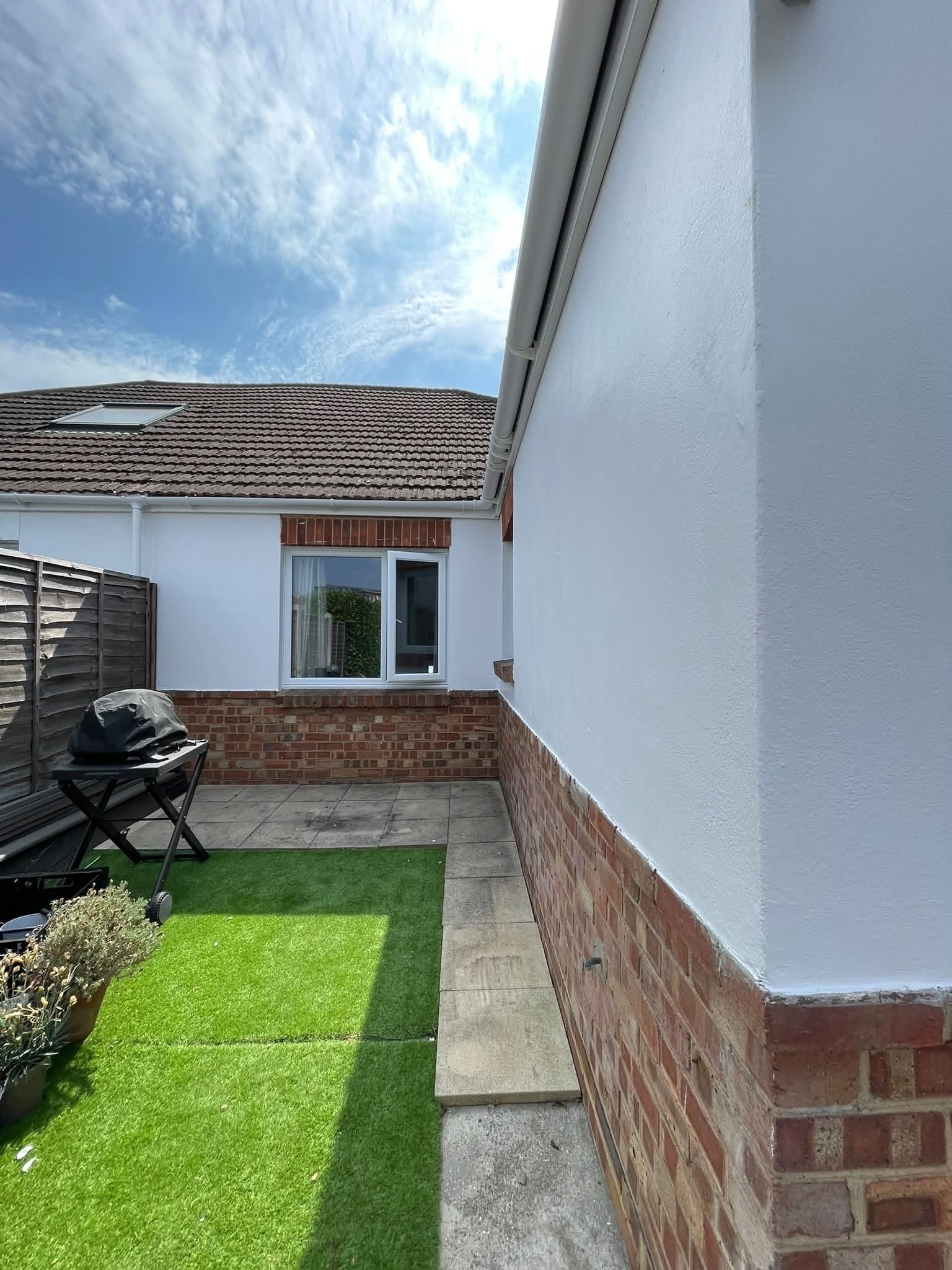 Bungalow exterior freshly painted in brilliant white masonry paint